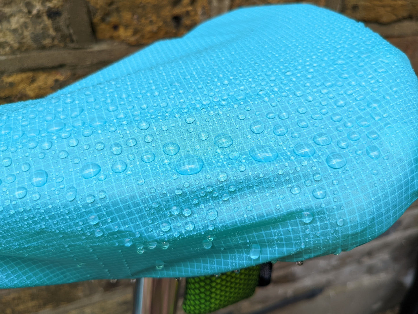 Saddlemac rain cover for a bicycle saddle with water beading on top