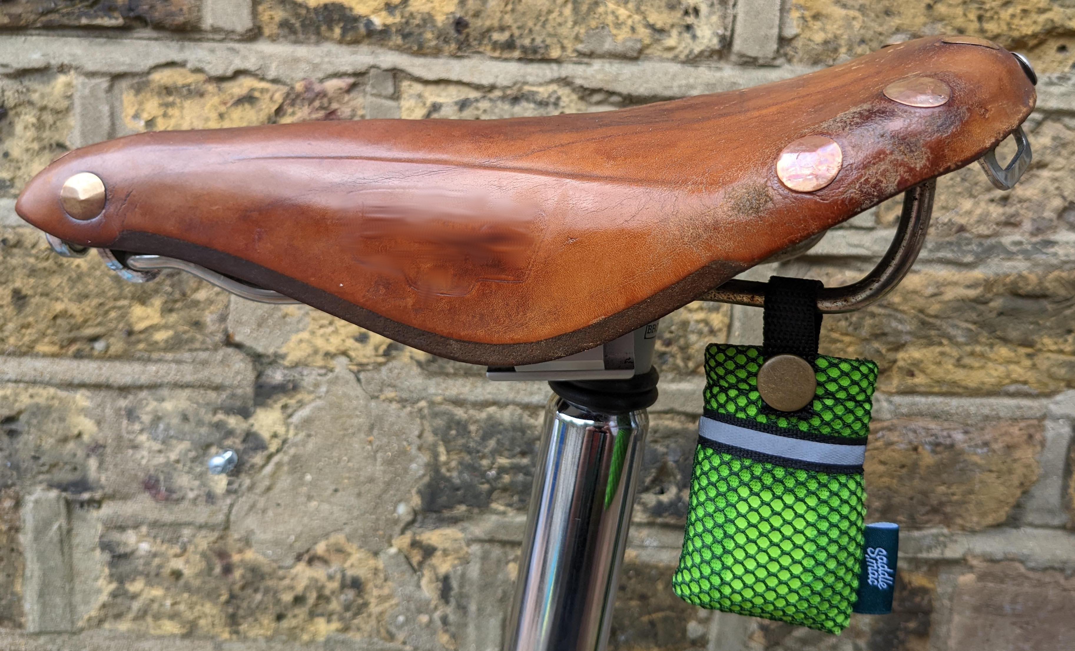 Saddlemac storage pouch clipped underneath a brown leather saddlle